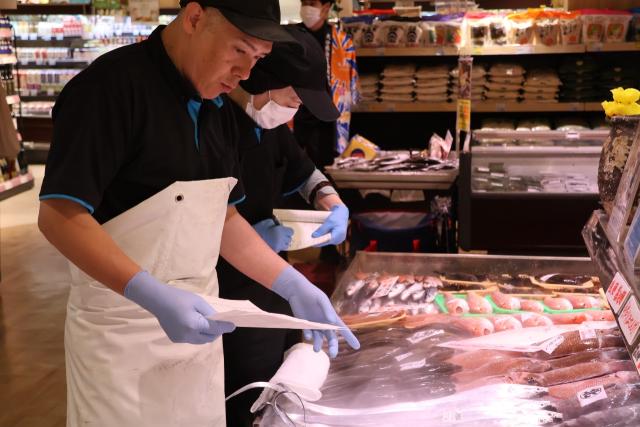 開店準備で魚に値付けをする店主